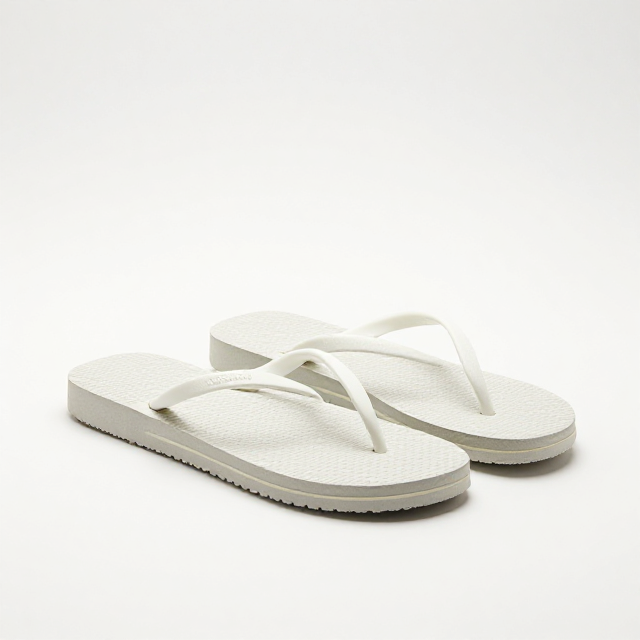 Fotografia de produto em estúdio com fundo branco infinito, um par de chinelos Havaianas Top Masculino na cor branca, ângulo de 45 graus, iluminação suave destacando a pureza do design. Sem texto na imagem, apenas visual.
